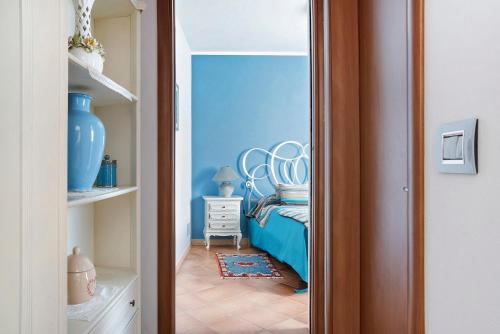1 dormitorio con cama y pared azul en La Corte di Langa alloggio Rubino, en Albaretto Della Torre 