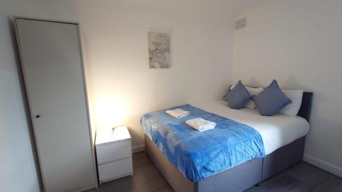 Cette petite chambre comprend un lit avec des oreillers bleus. dans l'établissement Kings City Centre Apartments, à Londres