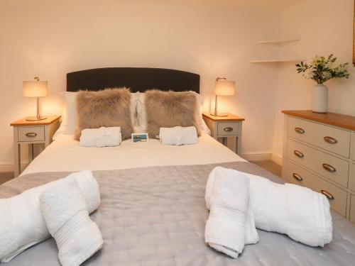 a bedroom with a large white bed with two lamps at Inglewood Court in Carnforth