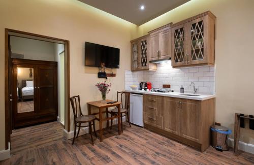 eine Küche mit Holzschränken sowie einem Tisch und Stühlen in der Unterkunft Level Suites - 203 in Istanbul