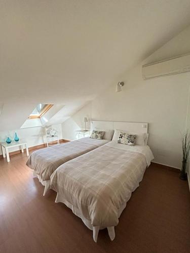 a white bedroom with a large bed in a room at Ronda Navarra by Valdesierra in Béjar