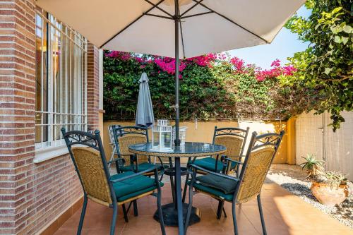 Una mesa y sillas con una sombrilla en un patio. en Garden Sweets Chalet, en Orihuela