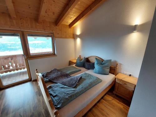 a bedroom with a bed with blue pillows on it at Ferienwohnung am Arzberg in Schwaz