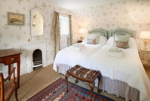 a bedroom with two beds and a fireplace at Coral Cottage at Castle Howard in York