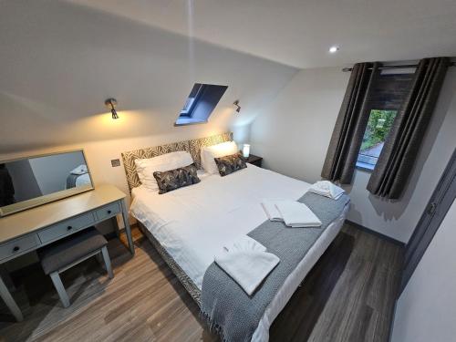 Dormitorio con cama, escritorio y TV en Melfort Pier & Harbour Resort en Kilmelfort