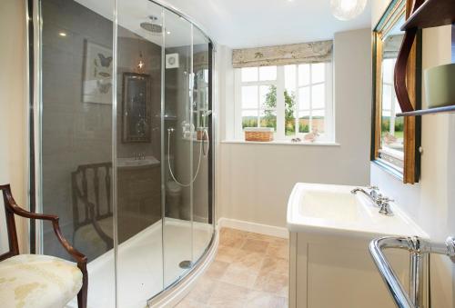 a bathroom with a shower and a sink at Coral Cottage at Castle Howard in York