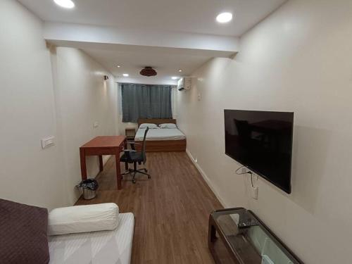 a small room with a bed and a tv on a wall at Private Studio Apartment in South Mumbai's Heart in Mumbai
