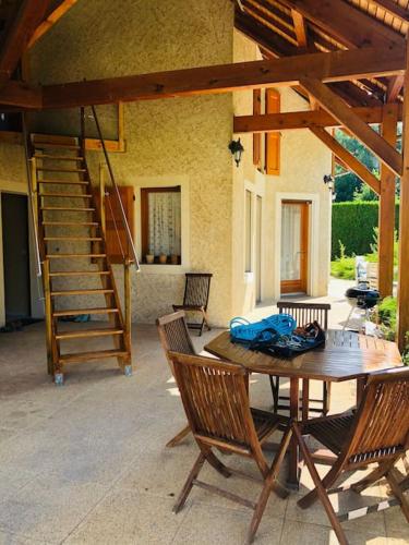 un patio avec une table et des chaises et un escalier dans l'établissement La Chouliere, superbe lodge en Vallée du Champsaur, à Chabottes