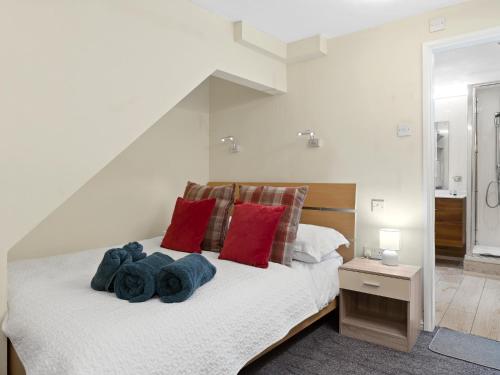 a bedroom with a white bed with red pillows at Contractor-Friendly 3-Bed Cottage in Prime Ulverston Location - Pass the Keys in Ulverston
