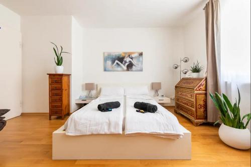 een slaapkamer met een groot wit bed en 2 schoenen bij Willkommen in München nahe Zentrum und Oktoberfest in München