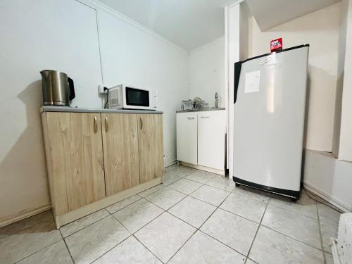 uma cozinha com um frigorífico e um micro-ondas em Nómada Hostel Osorno em Osorno