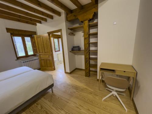 a bedroom with a bed and a desk and a chair at Posada Cabañes in Cabañes