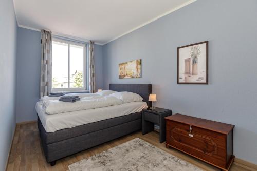 Un dormitorio con una cama grande y una ventana en Strandjuwel 222, en Kühlungsborn