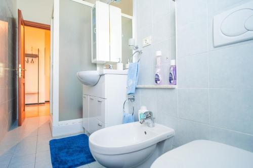een witte badkamer met een toilet en een wastafel bij Alloggio Gallinara a due passi dal mare in Liguria in Albenga