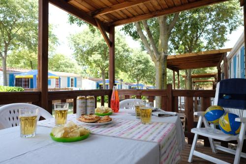 - une table avec de la nourriture et des boissons sur une terrasse dans l'établissement Happy Camp Mobile Homes in Camping Bella Austria, à Sankt Peter am Kammersberg