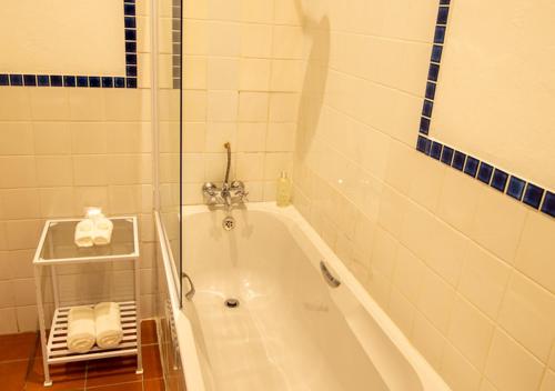 a bathroom with a bath tub with towels in it at Hotel du Vin Franschhoek in Franschhoek