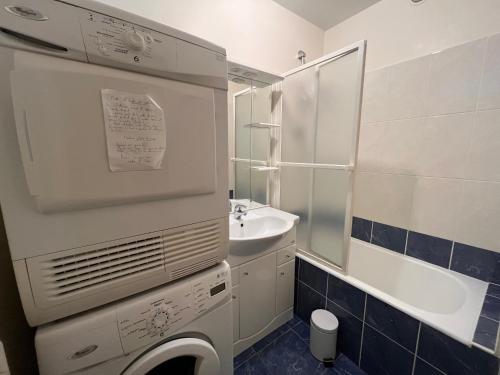 La salle de bains blanche est pourvue d'un lavabo et d'une baignoire. dans l'établissement Appartement T3 avec balcon et parking, à deux pas de la plage - FR-1-197-182, à Les Sables-dʼOlonne