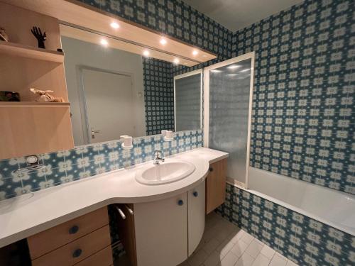 une salle de bain avec un lavabo, un miroir et une baignoire dans l'établissement Appartement confortable avec vue sur l'océan, 2 chambres et balcon - FR-1-197-201, à Les Sables-dʼOlonne
