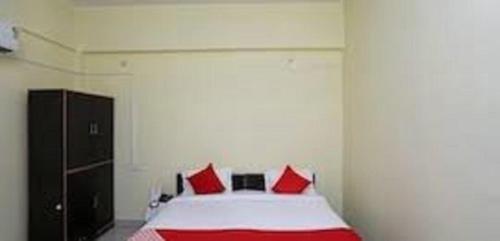 a bedroom with a bed with red pillows at Hotel YOGIRAJ LODGING BOARDIING,Deulgaon Raja 