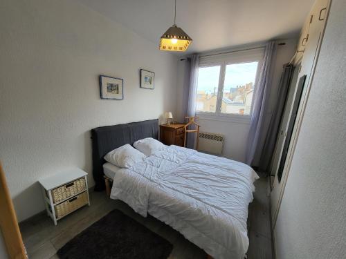 une petite chambre avec un lit et une fenêtre dans l'établissement Appartement T2 rénové face mer avec balcon, à 150m de la plage et 300m des commerces - FR-1-92-611, à Les Sables-dʼOlonne