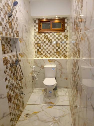 um banheiro com um vaso sanitário branco e um chuveiro em Aourir's new appartement em Agadir