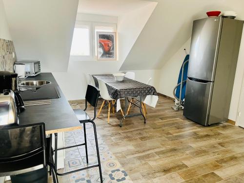 une cuisine avec une table et un réfrigérateur dans l'établissement Mosaïque Gare Un-Séjour-à-Part, à Metz