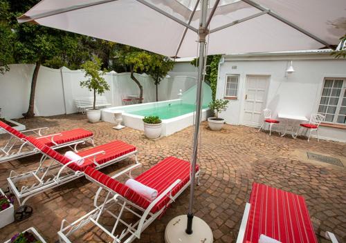 a group of chairs and an umbrella and a swimming pool at Hotel du Vin Franschhoek in Franschhoek