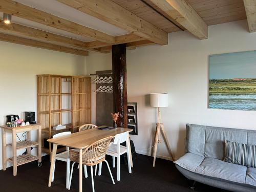 een woonkamer met een tafel en een bank bij Hotel Posthuys Vlieland in Oost-Vlieland