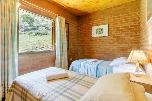 聖本圖－杜薩普卡伊的住宿－Chalé Vale do Coimbra，带窗户的客房内的两张床