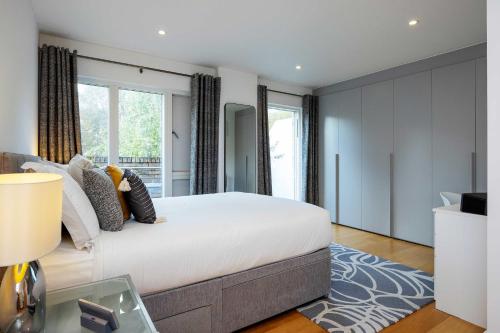 a bedroom with a large bed and a large window at Veeve - Here Comes the Sun in London