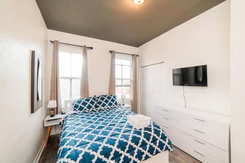 a white bedroom with a bed and a tv at Comfortable and Walkable - Off-Street Parking in Pittsburgh
