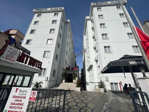 two tall white buildings with an umbrella in front of them at Tempo Florya Otel in Istanbul