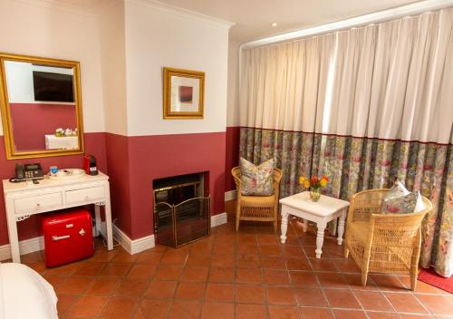 a living room with a fireplace and a table and chairs at Hotel du Vin Franschhoek in Franschhoek