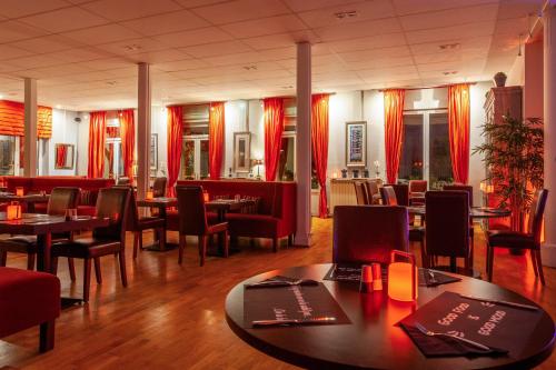 維泰勒的住宿－Providence Hotel，一间带桌椅和红色窗帘的餐厅