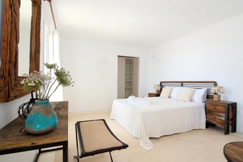 una camera da letto con un letto bianco e un vaso blu di Villa Mezcal by Mykonos Mood a Mykonos Città