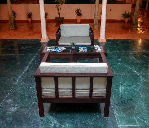 a coffee table with a chair on top of a floor at Mango Hill La Serene Puducherry in Pūrnānkuppam