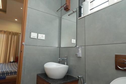 y baño con lavabo blanco y espejo. en WinterHome homestay en Munnar