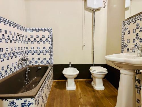 ein Badezimmer mit einer Badewanne, einem WC und einem Waschbecken in der Unterkunft Domus An- Two Bedrooms Apartment -Antique and Historical Home in Siena