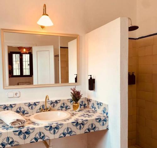 y baño con lavabo y espejo. en Villa Lavanda by Época Suites, en El Castillo de las Guardas