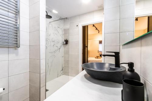 La salle de bains est pourvue d'un lavabo et d'une douche. dans l'établissement Exclusive Apartments Barcelona 4 personas St Pere, à Terrassa