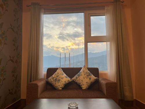 a couch sitting in front of a large window at Little Sikkim Inn in Gangtok