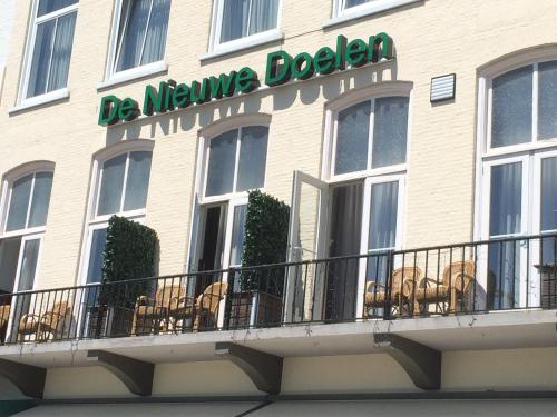 a large white building with a dog on the balcony at Hotel en privé-wellness De Nieuwe Doelen in Middelburg