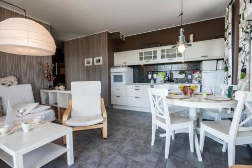 a kitchen and living room with a table and chairs at Apartament Trap in Karwia