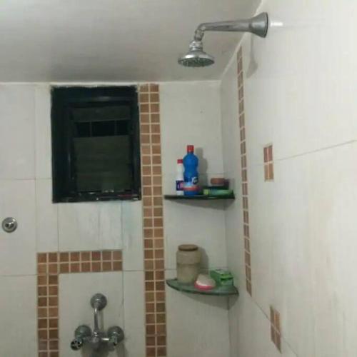a bathroom with a shower with a sink and a window at Luxurious 2BHK bunglow with garden in Solapur