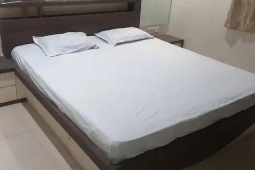 a large white bed with two pillows on it at Luxurious 2BHK bunglow with garden in Solapur