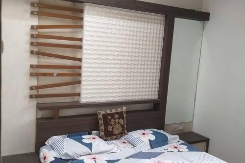 1 dormitorio con ventana y 1 cama con silla en Luxurious 2BHK bunglow with garden en Solapur
