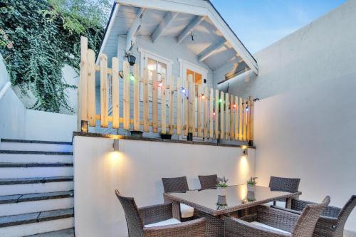 a patio with a table and chairs and a balcony at Beach Hut Hideaway By My Getaways in Brighton & Hove