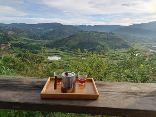 uma bandeja com uma cafeteira e copos numa mesa em Midori Coffee Farm em Da Lat