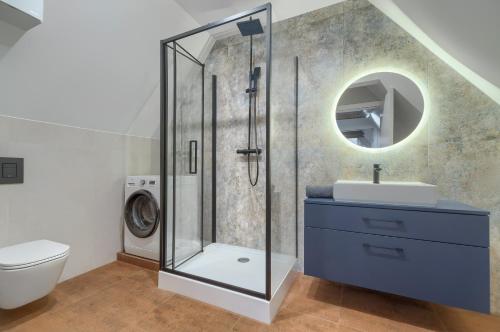 ein Bad mit einer Dusche, einem WC und einem Waschbecken in der Unterkunft Apartament Gran in Stettin