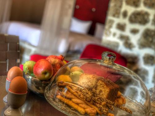 a table with a glass dish of food and fruits and vegetables at Ξενώνας Σαν Παραμύθι in Sinoikía Mési Trikálon